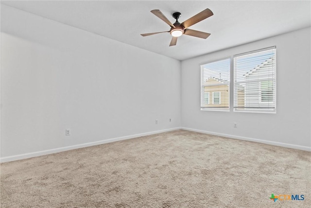 carpeted spare room with baseboards and ceiling fan