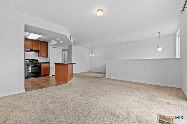 unfurnished living room with an inviting chandelier, baseboards, carpet, and visible vents