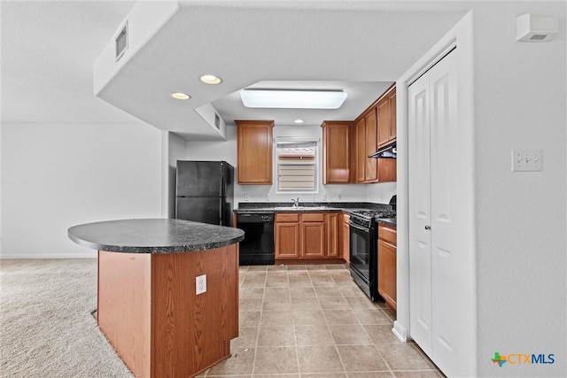 kitchen with dark countertops, a sink, under cabinet range hood, a kitchen island, and black appliances