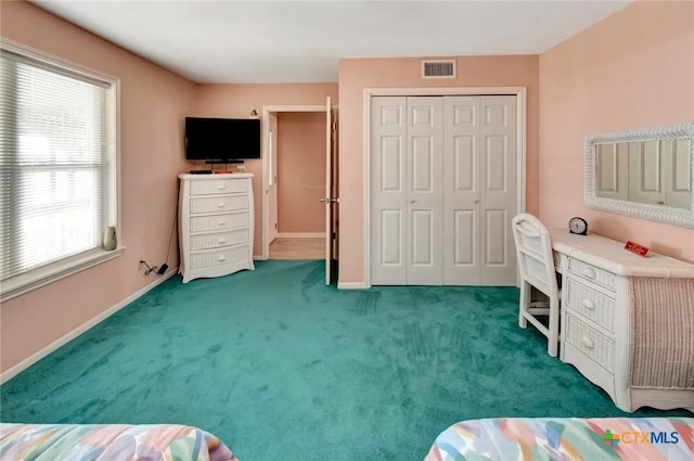 bedroom with baseboards, a closet, visible vents, and carpet flooring