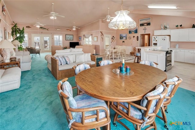 dining area featuring light carpet and vaulted ceiling