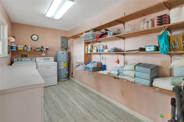 clothes washing area featuring laundry area, electric panel, washer and clothes dryer, light wood-style flooring, and water heater