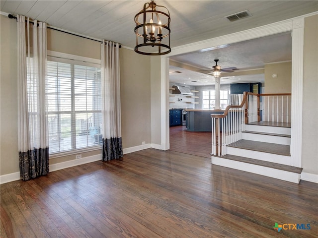 interior space featuring baseboards, visible vents, dark wood-style flooring, stairs, and ceiling fan with notable chandelier