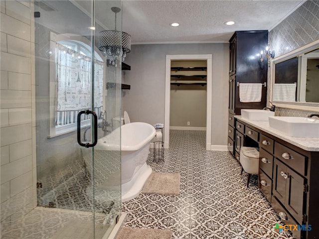 bathroom featuring ornamental molding, a soaking tub, a sink, and a textured ceiling