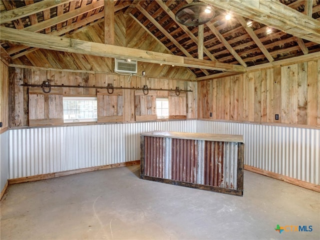 interior space with lofted ceiling, concrete floors, and a wall mounted air conditioner