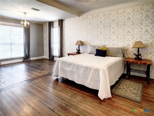 bedroom featuring wallpapered walls, dark wood finished floors, visible vents, and baseboards