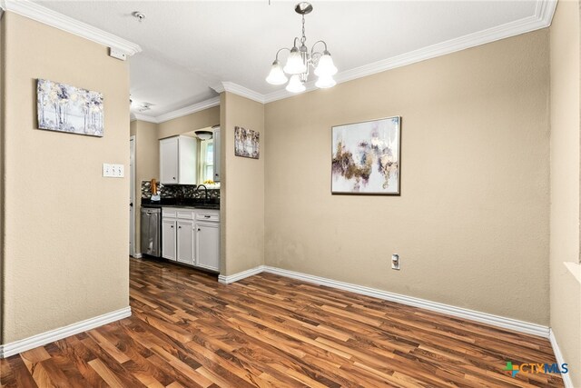 unfurnished dining area featuring dark wood-style floors, baseboards, a chandelier, and crown molding