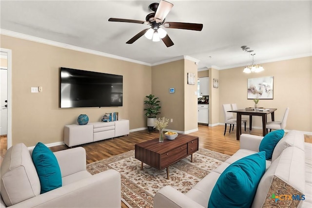 living area with baseboards, ornamental molding, wood finished floors, and ceiling fan with notable chandelier