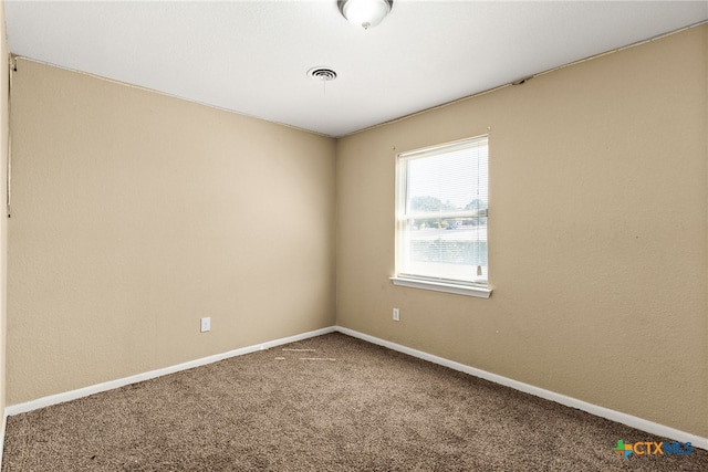 carpeted spare room with visible vents and baseboards