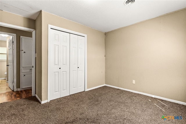 unfurnished bedroom with baseboards, a closet, visible vents, and carpet flooring