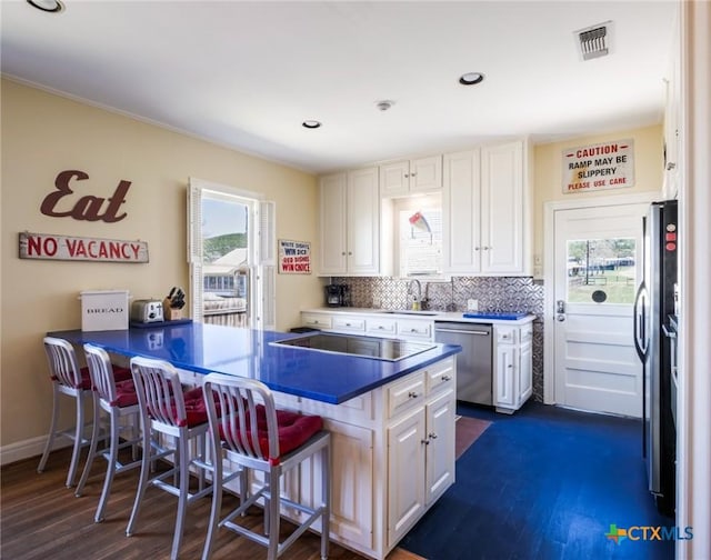 601 Lakewood Dr, Burnet, TX 78611 - kitchen with a peninsula, white cabinetry, appliances with stainless steel finishes, and a kitchen bar