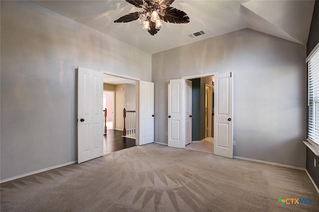 unfurnished bedroom featuring carpet flooring, vaulted ceiling, and ceiling fan