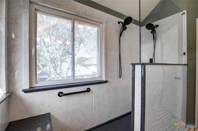 bathroom featuring lofted ceiling and tiled shower