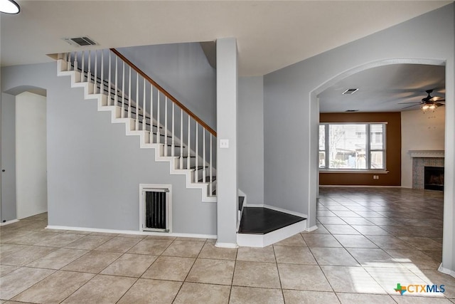 entrance foyer with ceiling fan, light tile patterned floors, and a tiled fireplace