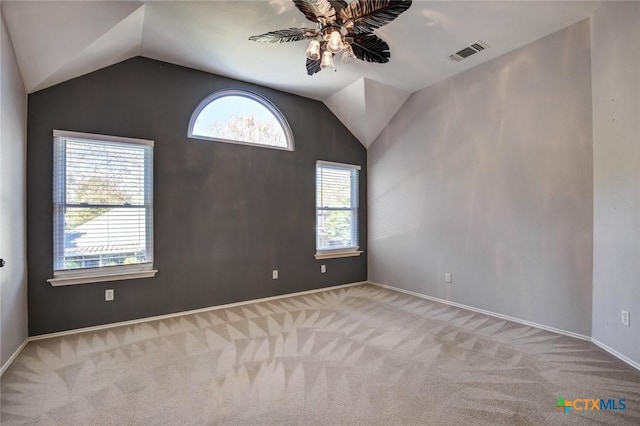 carpeted empty room featuring ceiling fan and vaulted ceiling