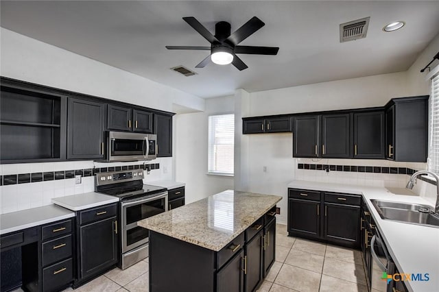 kitchen featuring tasteful backsplash, stainless steel appliances, ceiling fan, sink, and light tile patterned floors