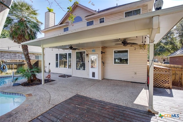 rear view of property featuring a pool side deck and a patio area