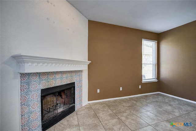 unfurnished living room featuring a tile fireplace and light tile patterned flooring