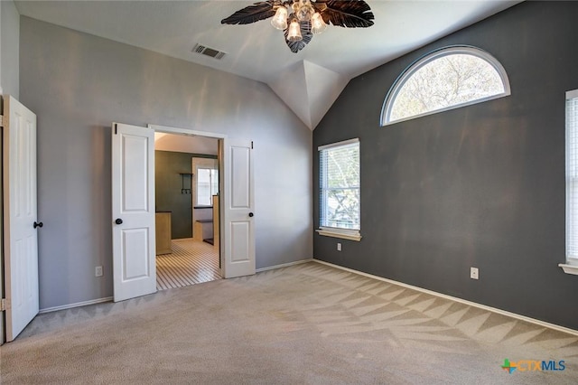 unfurnished bedroom with ceiling fan, light colored carpet, and lofted ceiling