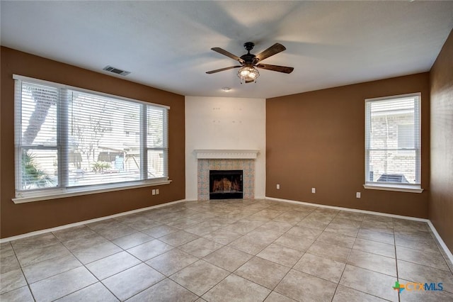 unfurnished living room with a fireplace, light tile patterned floors, and ceiling fan