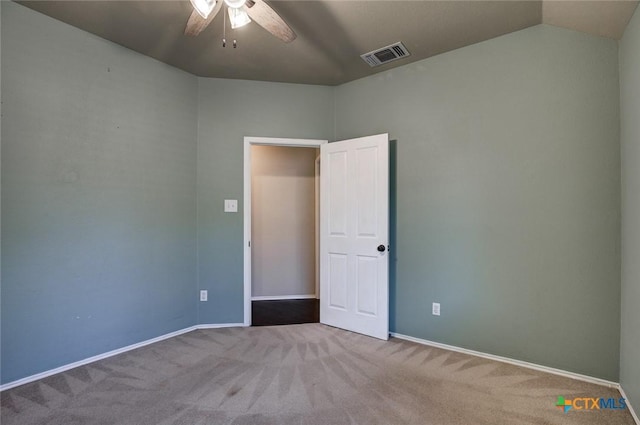 empty room featuring carpet flooring, vaulted ceiling, and ceiling fan