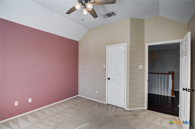 unfurnished bedroom featuring light carpet, a closet, ceiling fan, and lofted ceiling