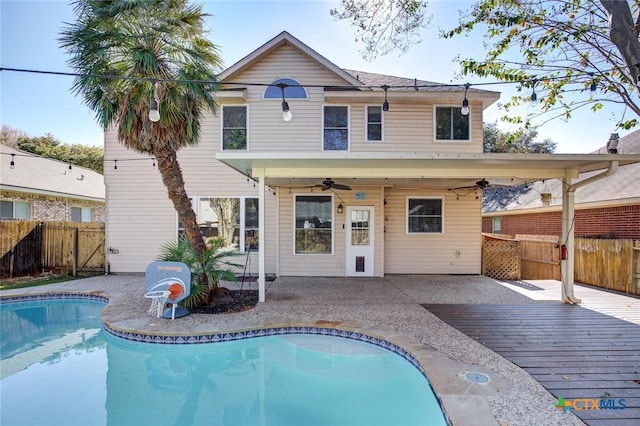 rear view of house featuring a swimming pool side deck, ceiling fan, and a patio area