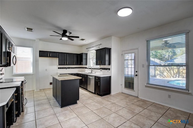 kitchen with plenty of natural light, a center island, backsplash, and appliances with stainless steel finishes