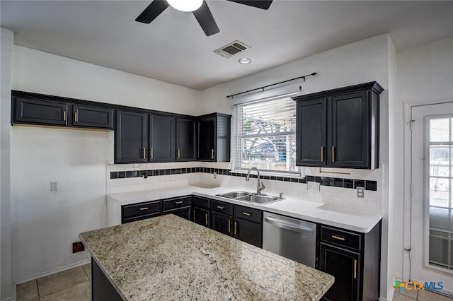 kitchen with backsplash, stainless steel dishwasher, ceiling fan, sink, and a kitchen island