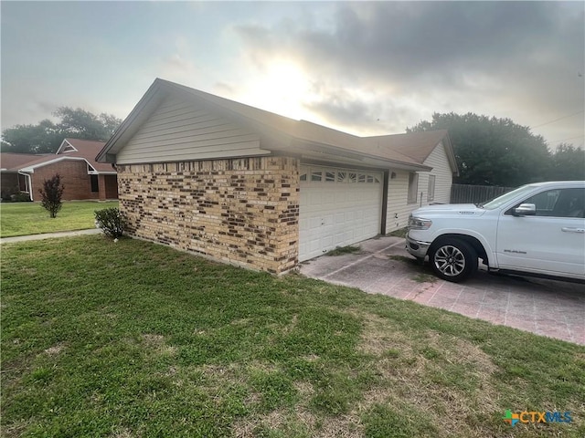 2402 Lago Trl, Killeen, TX 76543 - view of side of home featuring concrete driveway, an attached garage, a lawn, and brick siding