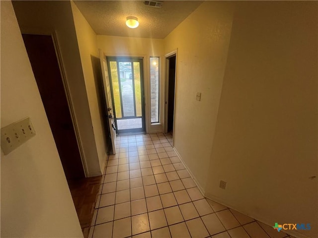 2402 Lago Trl, Killeen, TX 76543 - hall with light tile patterned floors, a textured ceiling, and baseboards