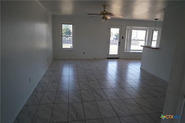 tiled spare room with ceiling fan and a healthy amount of sunlight