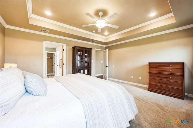 bedroom with a raised ceiling, visible vents, and carpet floors