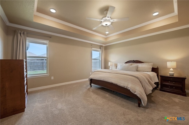 carpeted bedroom featuring a raised ceiling, recessed lighting, baseboards, and ornamental molding