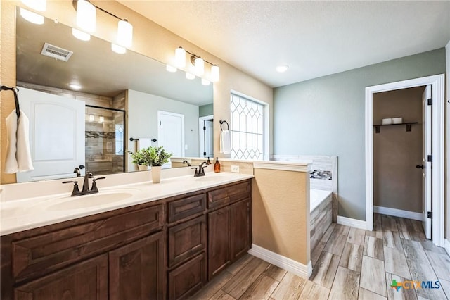 full bathroom featuring a sink, visible vents, a stall shower, and a bath