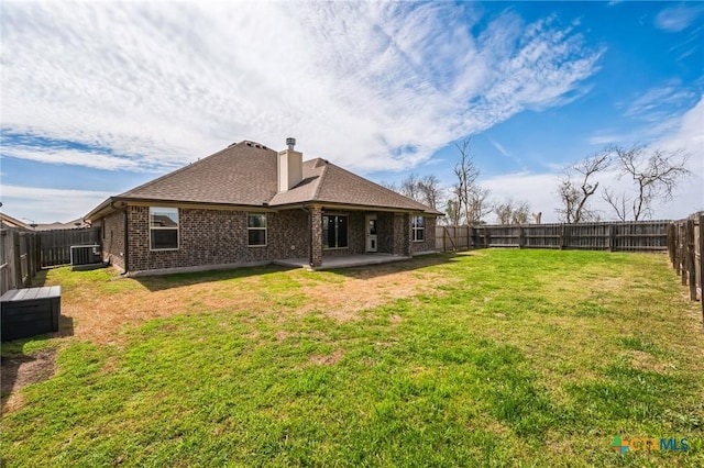 rear view of property with a patio, central AC, a fenced backyard, a yard, and brick siding