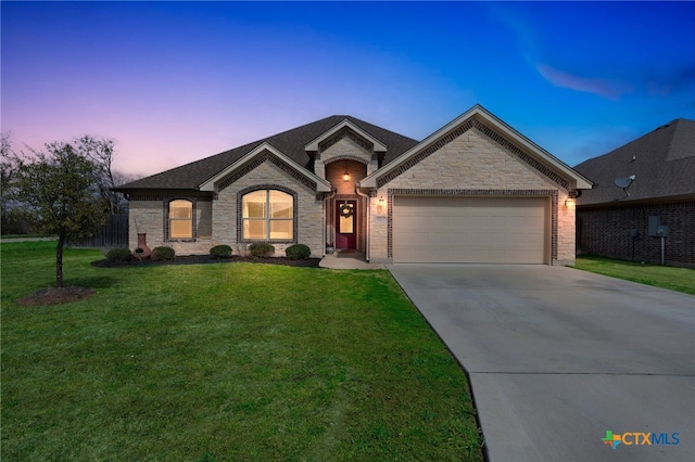 view of front of property featuring a yard, brick siding, a garage, and driveway