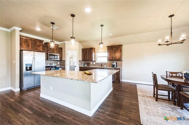 kitchen featuring a center island, dark wood finished floors, dark brown cabinetry, decorative backsplash, and stainless steel appliances