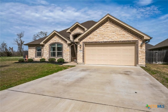 view of front of house featuring a garage, driveway, a front yard, and fence