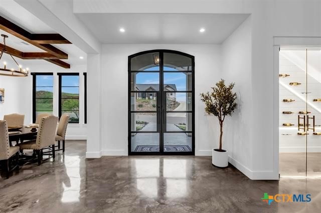 entryway with beamed ceiling and an inviting chandelier