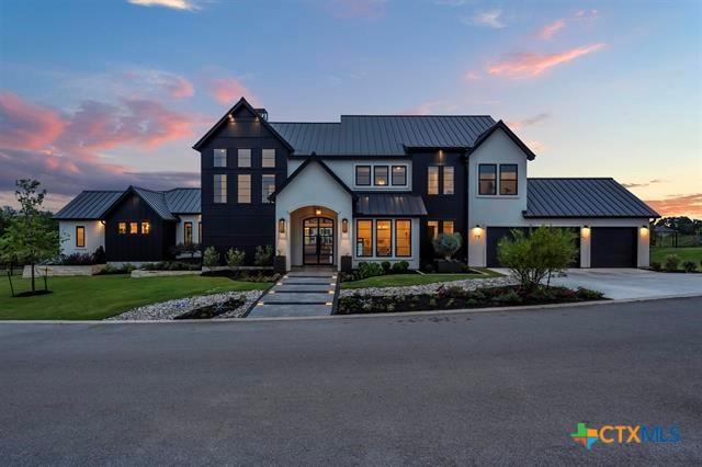 117 Legendary Estates Dr, Burnet, TX 78611 - modern farmhouse style home featuring metal roof, a standing seam roof, stucco siding, and a front lawn