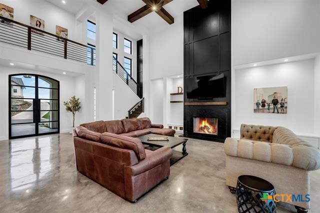 living room with a large fireplace and a high ceiling