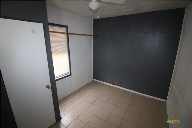 tiled empty room featuring a textured ceiling and ceiling fan