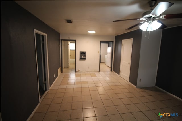 unfurnished room with ceiling fan and light tile patterned floors