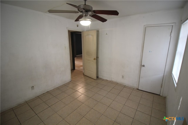 tiled empty room with ceiling fan