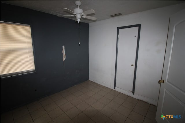 tiled empty room with ceiling fan