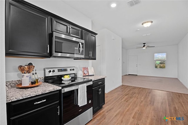 5806 Gulf Mdw, Converse, TX 78109 - kitchen featuring stainless steel appliances, dark cabinetry, light wood-style floors, and a ceiling fan