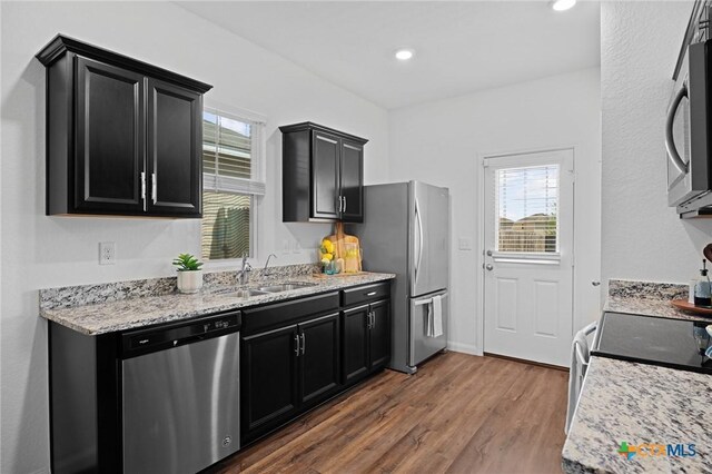 5806 Gulf Mdw, Converse, TX 78109 - kitchen featuring appliances with stainless steel finishes, dark cabinets, dark wood-style floors, light stone counters, and recessed lighting