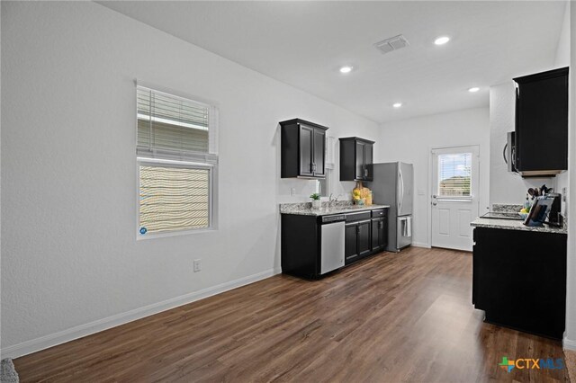 5806 Gulf Mdw, Converse, TX 78109 - kitchen featuring appliances with stainless steel finishes, dark cabinetry, dark wood-type flooring, recessed lighting, and light stone countertops