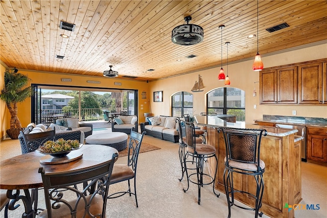 carpeted dining room with wooden ceiling